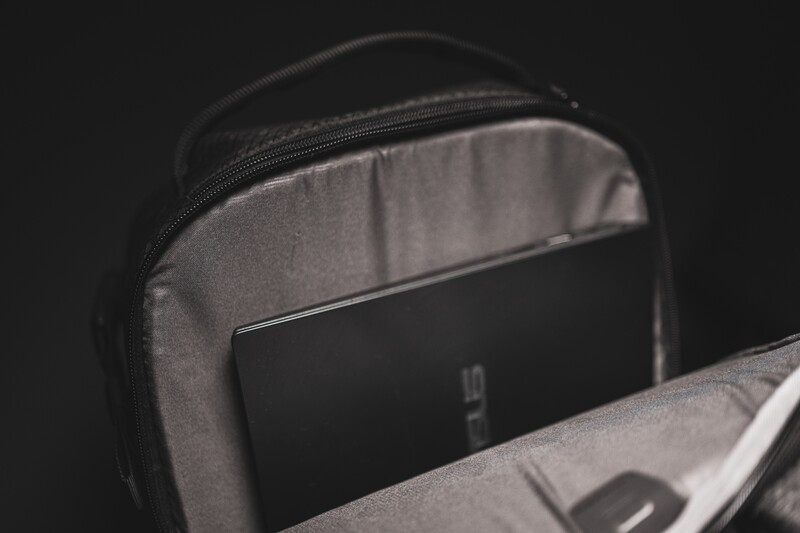 Camera bag interior showing padded gray compartment with smartphone and black device inside.