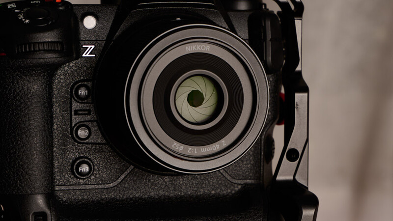 Close-up of a Nikon Z mirrorless camera with mounted lens showing aperture blades in the optical center.
