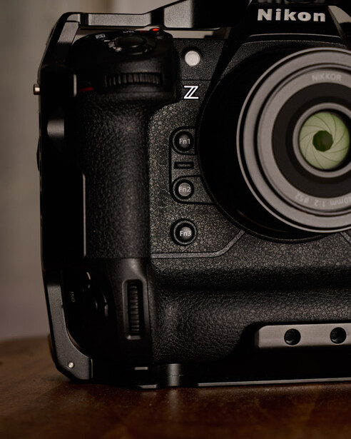 Close-up of a Nikon Z camera body showing the grip, control buttons, and lens mount in studio lighting.