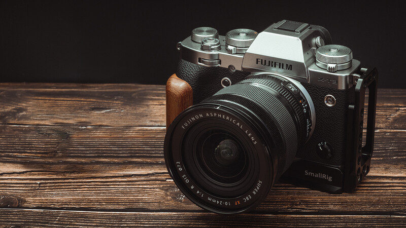Fujifilm X-T5 mirrorless camera with XF 18-55mm lens on wooden surface.