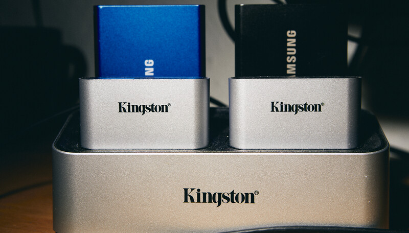 Kingston external storage devices arranged in a docking station, showing silver metal bodies with blue and black boxes above.