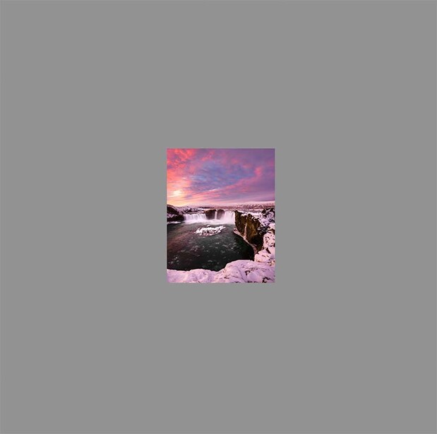 Composite image with pink-purple sunset sky above dark coastal rocks and waves.