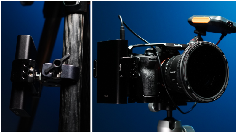 Professional cinema camera with mounted microphone and lighting equipment against blue background.