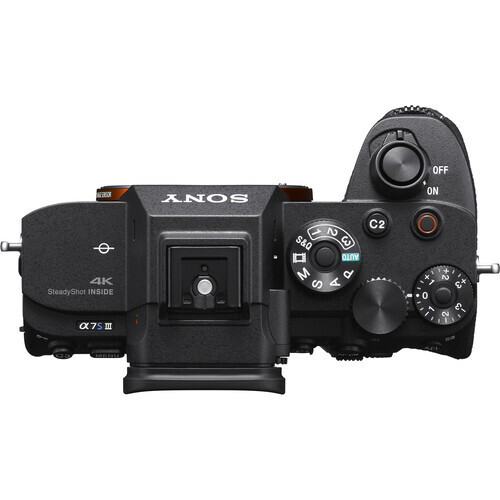 Top-down view of a Sony mirrorless camera body with control dials and LCD screen visible.