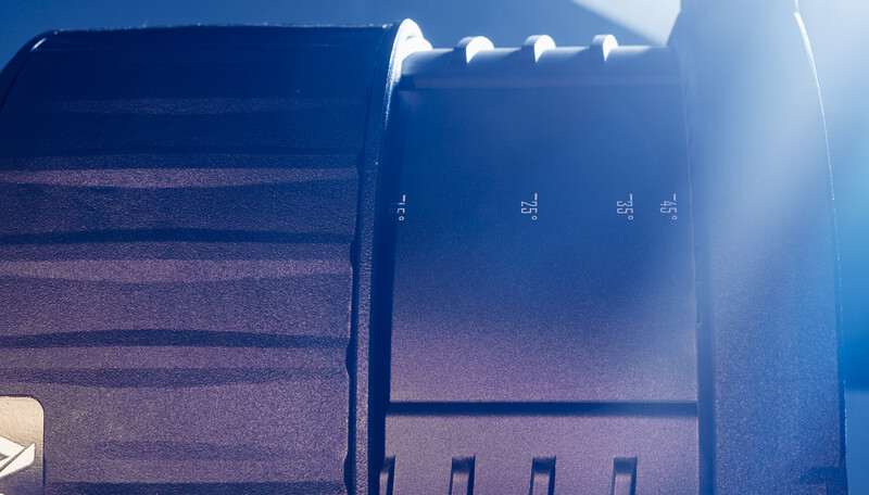 Close-up of camera lens aperture blades with bright backlight creating lens flare and blue tones.