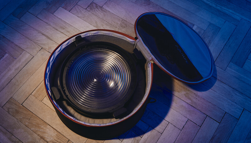 Overhead view of an open pot with reflective ridged interior on wooden herringbone flooring with blue cast lighting.