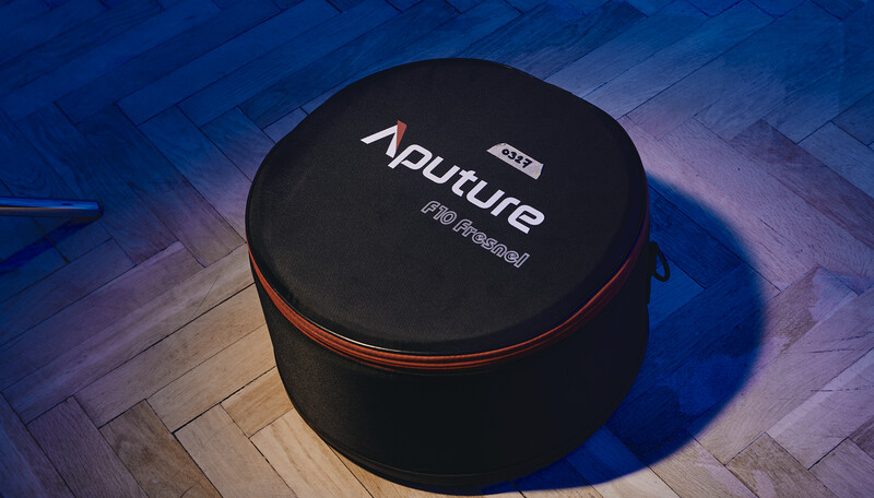 Black cylindrical equipment case with red trim and white text branding on wooden herringbone flooring.