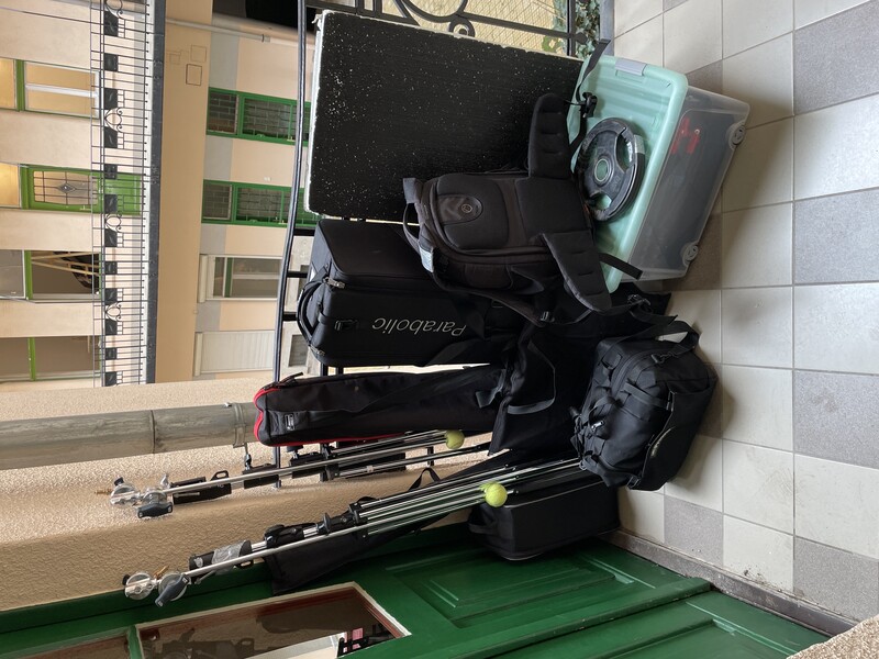 Photography and video equipment arranged on a balcony overlooking a European courtyard.