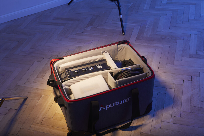 Aputure equipment case organized with dividers containing camera gear on herringbone wood flooring.