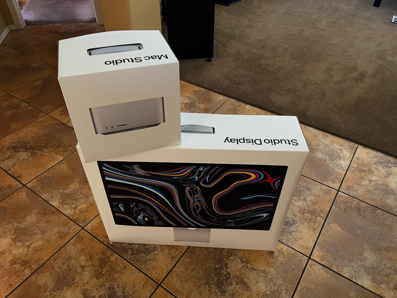 White product packaging boxes displayed on tile flooring with abstract black and orange liquid swirl design visible on front panel.