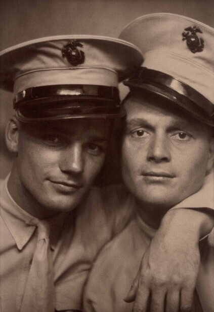 Two men in military caps posing shoulder-to-shoulder for a sepia-toned portrait.