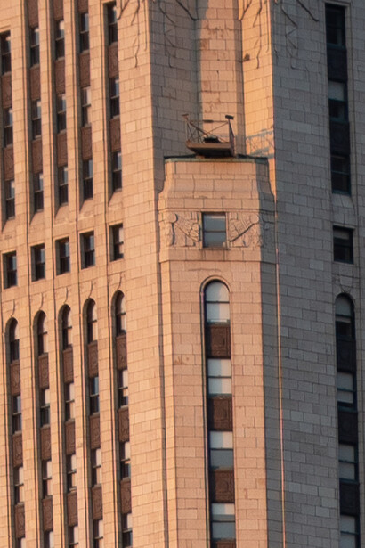 Vertical window and architectural detail on terracotta brick building facade.