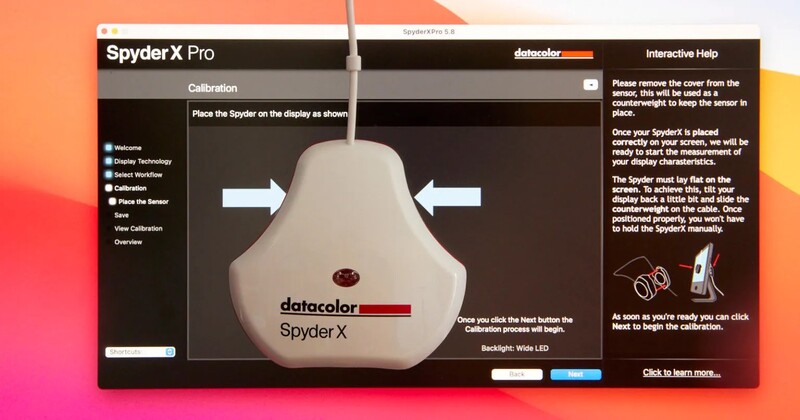 Screenshot of Spyder X Pro calibration software displaying device placement instructions on a colorful gradient background.