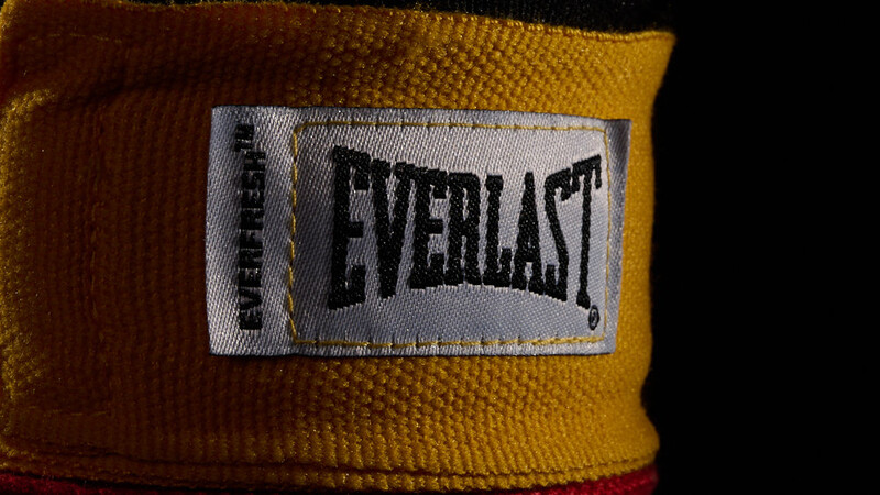 Close-up of Everlast brand label on yellow boxing hand wrap with red binding.