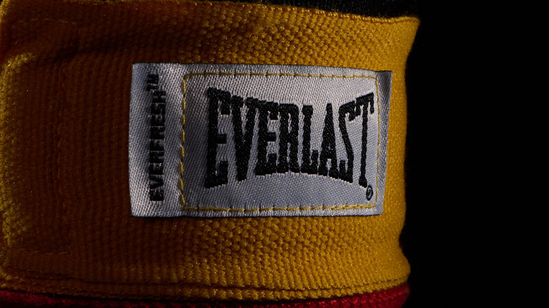 Close-up of Everlast brand boxing hand wrap label on yellow and red fabric.