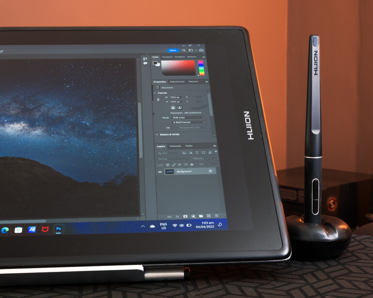 Huion pen display tablet showing photo editing software with a nighttime landscape image on screen.