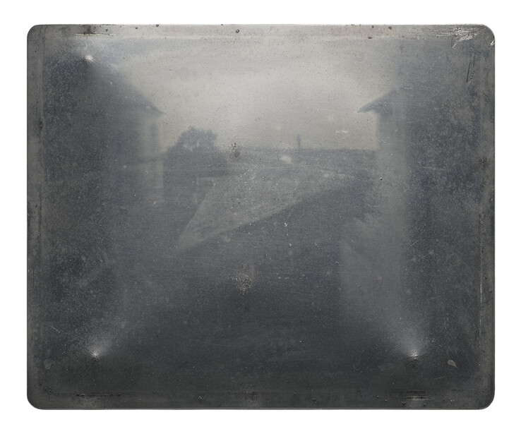 Architectural structures emerge through dense fog and mist in this atmospheric black and white photograph.