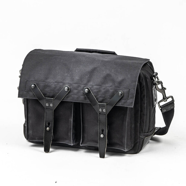 Dark gray canvas messenger bag with leather straps and metal hardware, shown against white background.