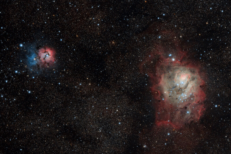 Deep space photograph showing two nebulae with glowing red hydrogen gas and embedded stars against a dark star field.