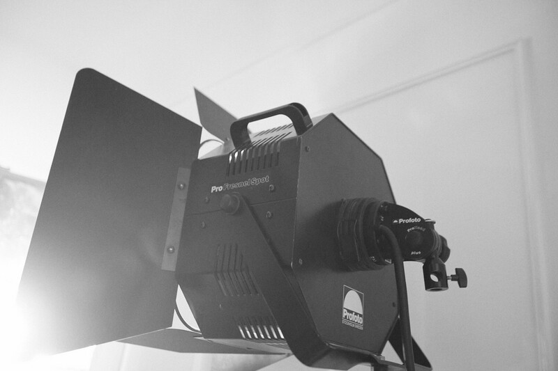 Professional LED studio light with barndoors and adjustable reflector mounted on stand.