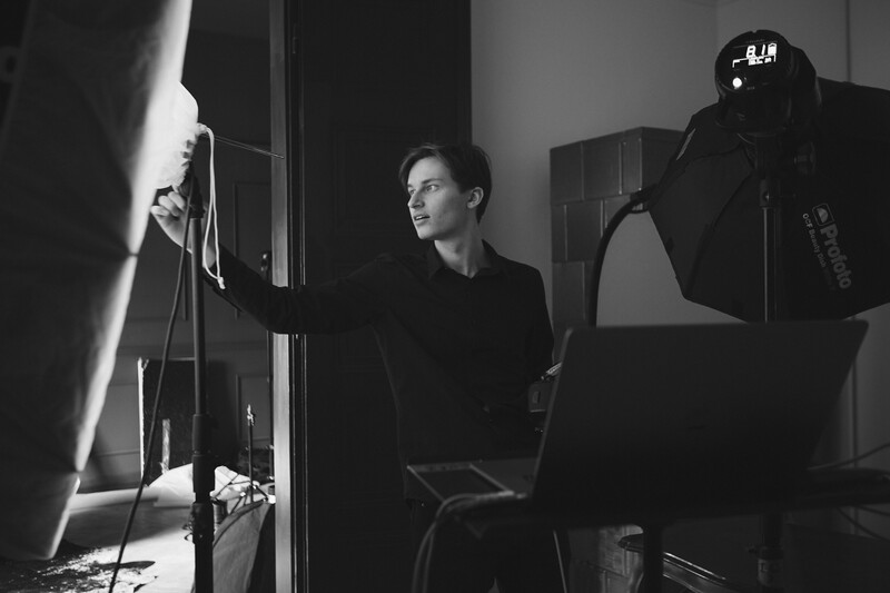 Person being interviewed or recorded in a studio with professional lighting setup and microphone.