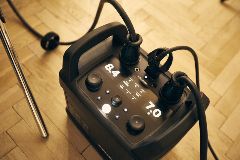 Audio interface with multiple knobs and controls positioned on wooden herringbone flooring.