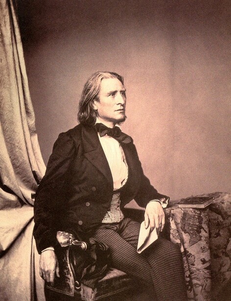 Portrait of a man in formal 19th-century attire seated against draped fabric backdrop.