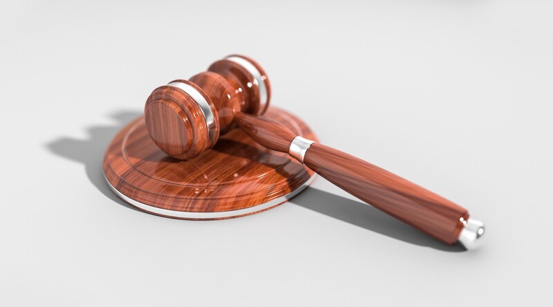 Wooden gavel and sound block rendered in 3D with polished finish and soft shadows.