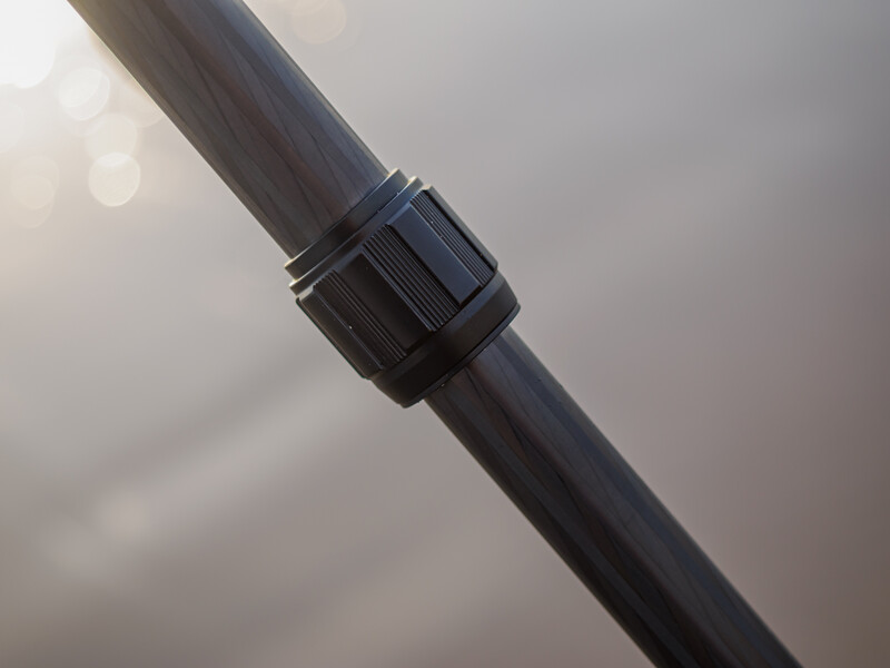 Close-up of a black pipe with an adjustable clamp band wrapped around it.