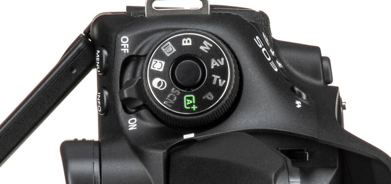 Top-down view of a DSLR camera's mode dial and control interface with manual exposure settings visible.