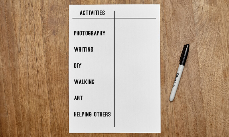 Worksheet with activities list and blank spaces for responses, photographed flat-lay style on wooden surface with marker.