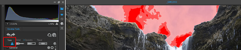 Screenshot of photo editing software showing histogram and raw development tools alongside landscape image with red thermal or false-color overlay.