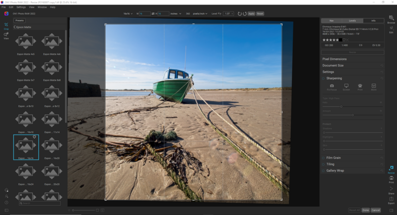 Screenshot of photo editing software displaying a beached green fishing boat on sand with rope in foreground.