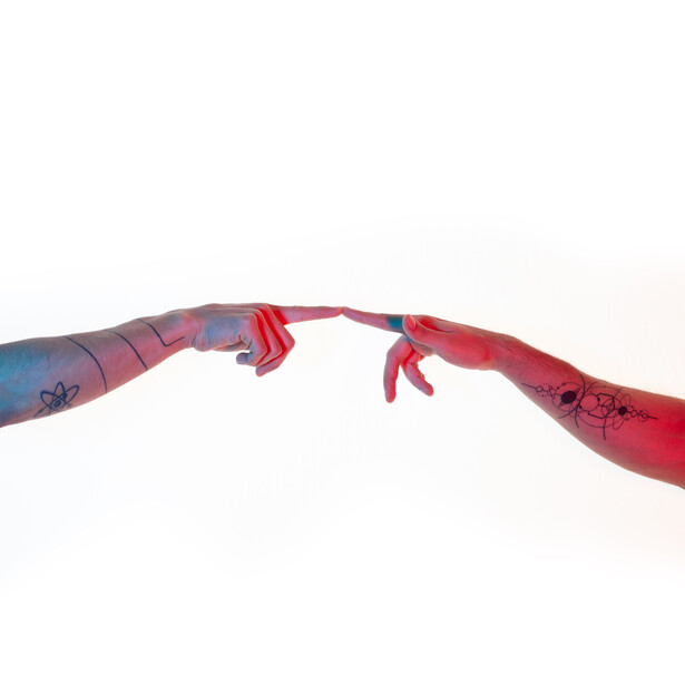 Two painted fabric strips connected by red cord knots against a white background.