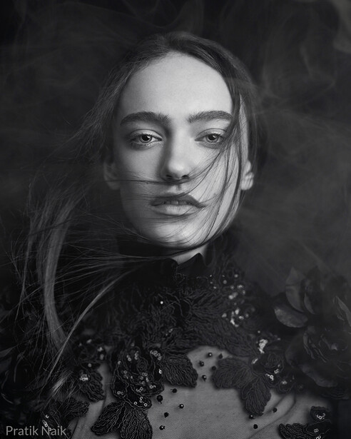 Black and white portrait of a woman with long dark hair and contemplative expression.