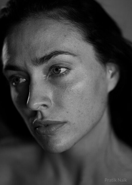 Black and white portrait of a person with defined facial features, looking directly at the camera with a neutral expression.