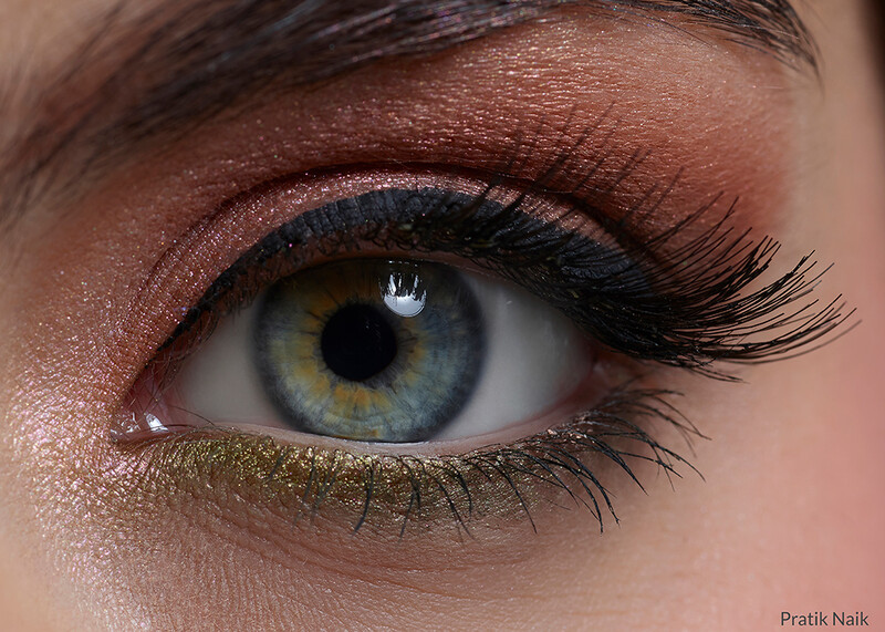 Close-up of a blue-green eye with warm brown eyeshadow, black eyeliner, and mascara.