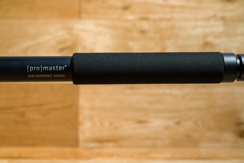 Promaster air support AS-85 monopod with foam grip extended horizontally against wooden background.