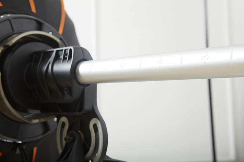 Close-up of a camera lens barrel with focus ring and black rubber grip sleeve attached to white cylindrical lens element.