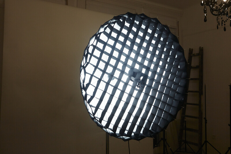 Large softbox with grid diffuser mounted on stand in studio interior.