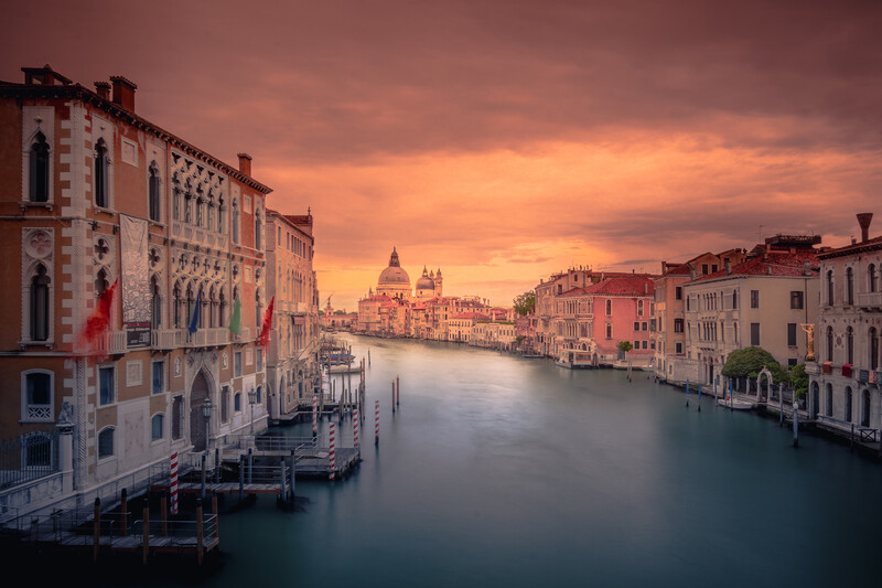 Grand Canal at sunset with Renaissance palaces and domed basilica in the distance.