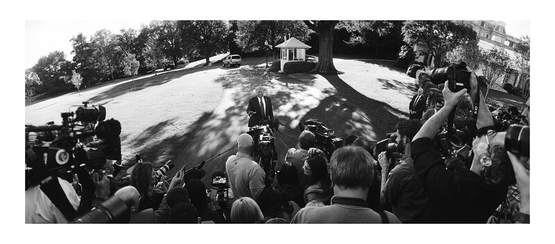 Large crowd of photographers and camera operators with professional equipment gathered on a lawn.