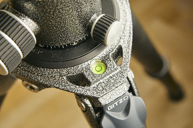 Close-up of a camera flash shoe mount covered in dust and debris, showing a green bubble level indicator.