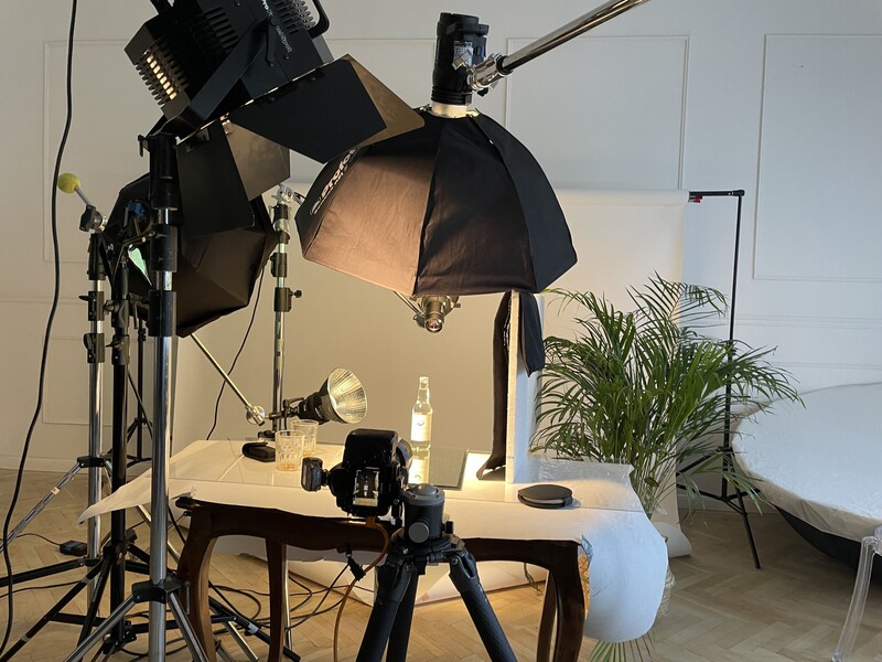 Professional studio setup with two large dome softboxes mounted on stands positioned above a tabletop product photography scene.