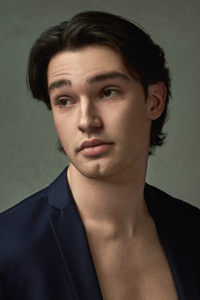 Male portrait against neutral gray background with professional studio lighting.