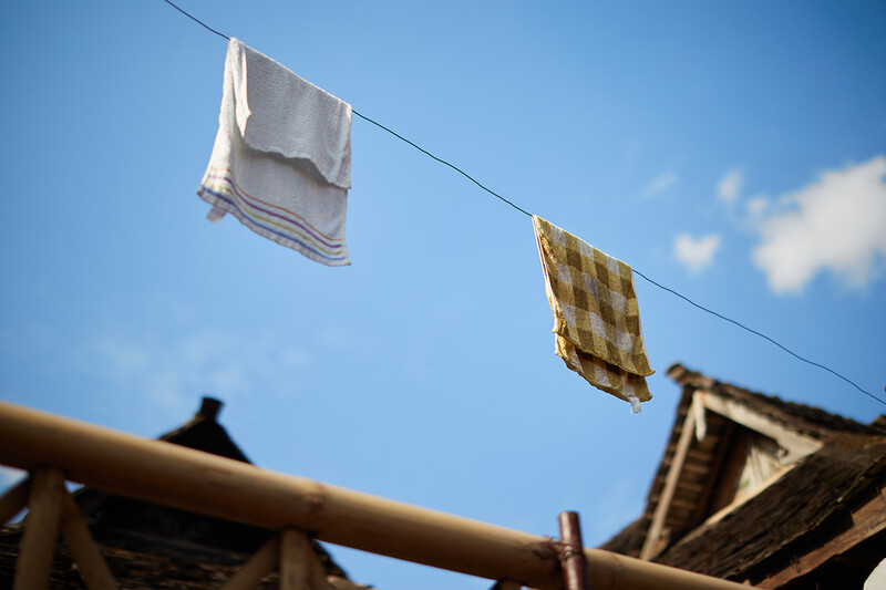 White and yellow checkered cloths hanging on a clothesline against a blue sky.