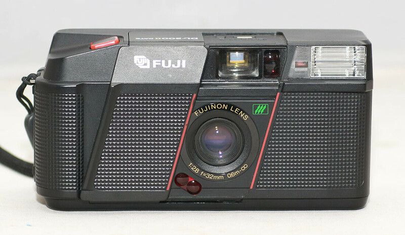 Fuji vintage compact film camera with Fujinon lens and built-in flash against white background.