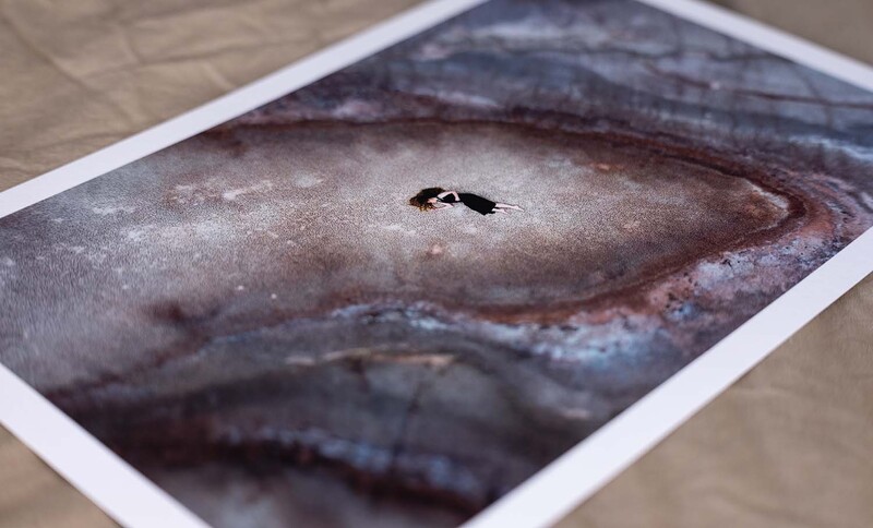 Printed photograph of a fish lying on a neutral surface, showing detailed skin texture and coloring.
