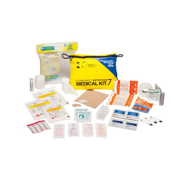 First aid and medical kit with bandages, gauze, antiseptic wipes, and emergency supplies organized in yellow pouch and clear bags.