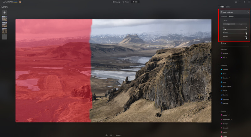 Screenshot of photo editing software showing a landscape image with a red adjustment layer partially covering it.